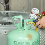 Sea Girt air conditioner repair technician servicing equipment with green pressure machine