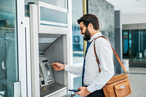Customer using outdoor ATM maintained by trustworthy NCR ATM service